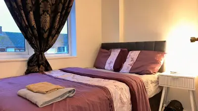 a bedroom with a bed with purple sheets and a window at Serene Guest Retreat in Basildon Comfort and Convenience Await in Basildon