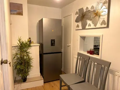 a kitchen with a refrigerator and a table and chairs at Serene Guest Retreat in Basildon Comfort and Convenience Await in Basildon
