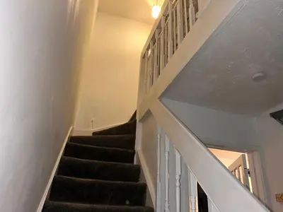 a staircase in a house with black carpet at Serene Guest Room Retreat in Basildon with Private Entrance in Basildon