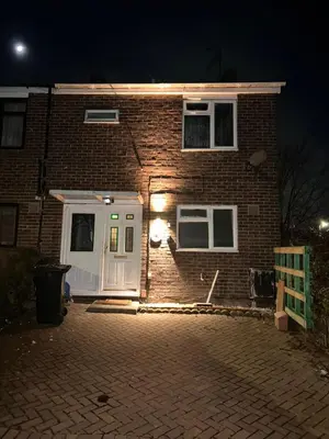 a brick house with a white door at night at Charming 4-Bedroom House Rental in Basildon, UK in Basildon