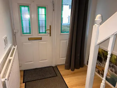 a hallway with a white door and a staircase at Charming 4-Bedroom House Rental in Basildon, UK in Basildon