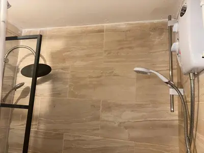 a shower in a bathroom with a glass door at Charming 4-Bedroom House Rental in Basildon, UK in Basildon