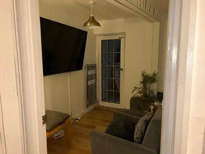a living room with a flat screen tv on the wall at Charming 4-Bedroom House Rental in Basildon, UK in Basildon