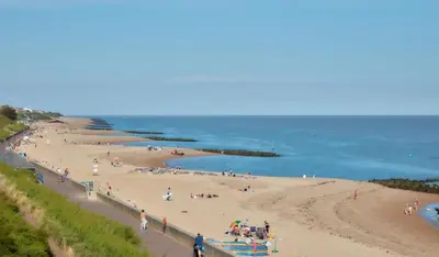 a group of people on a beach near the ocean at Caravan in Clacton-on-Sea in Little Clacton