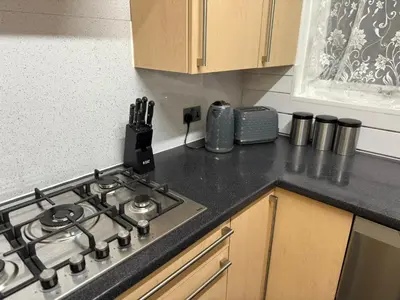 a kitchen counter with a stove top in a kitchen at Spacious 5 Bed House - Free Parking & WiFi in Basildon