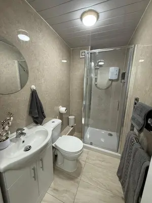 a bathroom with a toilet sink and a shower at Spacious 5 Bed House - Free Parking & WiFi in Basildon