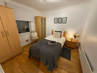 a small bedroom with a bed and a television at Spacious 5 Bed House - Free Parking & WiFi in Basildon
