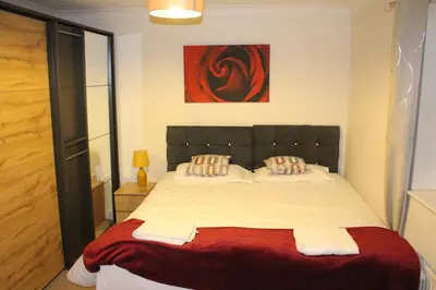 a bedroom with a large bed with a red blanket at 4 Bedroom house, Parking, Wi-Fi, Near Town Centre in Ipswich