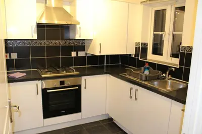 a kitchen with white cabinets and a sink at 4 Bedroom house, Parking, Wi-Fi, Near Town Centre in Ipswich