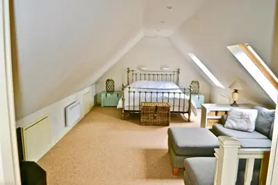 a attic room with a bed and a couch at Idyllic rural retreat, easy access to Cambridge