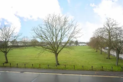 a field of grass with trees and a road at Chic & Cosy 2 Bed Maisonette with Freeparking near Chelmsford City Centre in Chelmsford