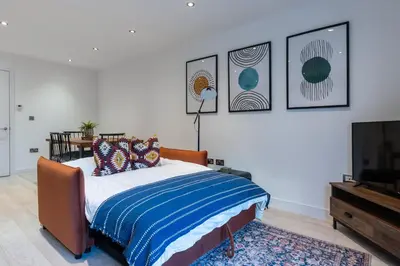 a bedroom with a bed and a flat screen tv at Station View - Modern Flat Near Centre & Station in Cambridge