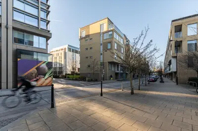 a person riding a bike on a city street at Station View - Modern Flat Near Centre & Station in Cambridge