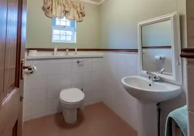 a bathroom with a white toilet and a sink at Tudor Style Seafront Home Sea Views Shoebury - Pass the Keys in Southend-on-Sea