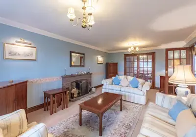 a living room with a couch and a fireplace at Tudor Style Seafront Home Sea Views Shoebury - Pass the Keys in Southend-on-Sea