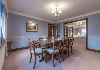 a dining room with a wooden table and chairs at Tudor Style Seafront Home Sea Views Shoebury - Pass the Keys in Southend-on-Sea