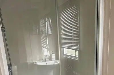 a bathroom with a sink and a window with blinds at Cabin - Sleeps 6 - Beach 10 minutes drive in Clacton-on-Sea
