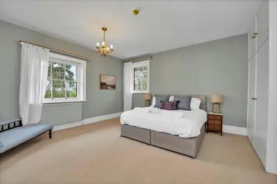 a large bedroom with a bed and a window at Finest Retreats - Clavering Hall in Saffron Walden