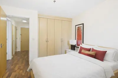 a bedroom with a large white bed with red pillows at Station Apartment in Cambridge