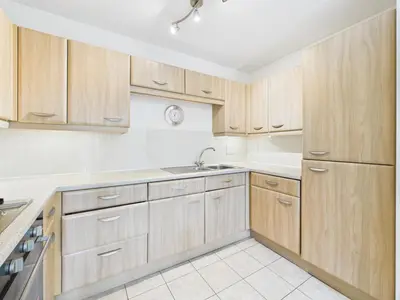 a kitchen with wooden cabinets and a sink at Station Apartment in Cambridge