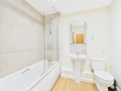 a white bathroom with a toilet and a sink at Station Apartment in Cambridge