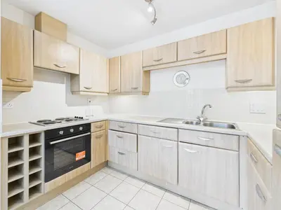 a kitchen with wooden cabinets and a sink at Station Apartment in Cambridge