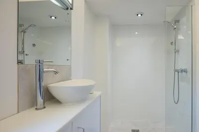 a white bathroom with a sink and a shower at The Orchard Annexe, Framlingham in Framlingham