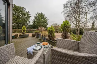 a patio with two wicker chairs and a table at The Orchard Annexe, Framlingham in Framlingham