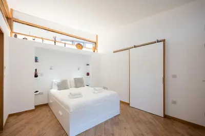 a white bedroom with a bed and a sliding glass door at The Orchard Annexe, Framlingham in Framlingham
