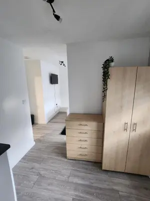 a room with a wooden cabinet and a tv at Ensuite premier rooms in Basildon