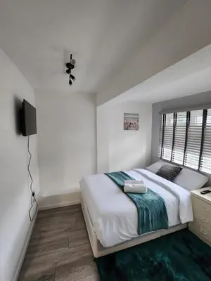 a bedroom with a large bed and a television at Ensuite premier rooms in Basildon