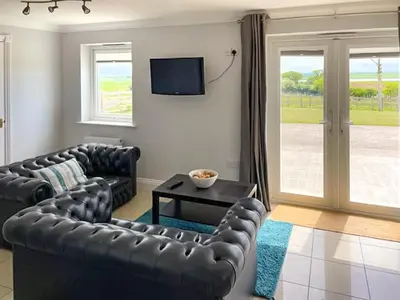 a living room with two leather couches and a television at Ivy No1 - Uk49251 in Althorne