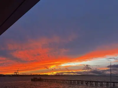 a sunset over the water with a pier in the foreground at Admiralty Lodge in Shotley Gate