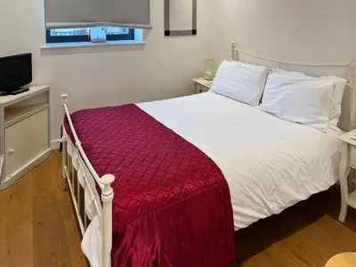 a bedroom with a white bed with a red blanket at Admiralty Lodge in Shotley Gate