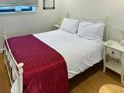 a bedroom with a white bed with a red blanket at Admiralty Lodge in Shotley Gate