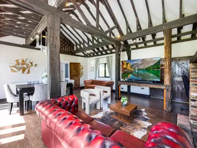 a living room with a red couch and a table at Essex Barn House - Uk48354 in Romford