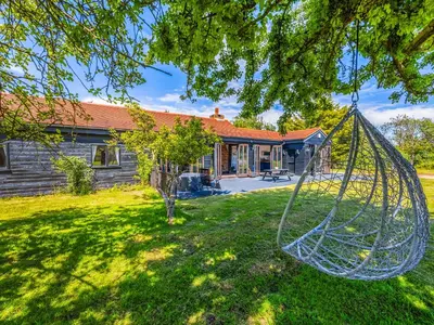 a yard with a swing in front of a house at Essex Barn House - Uk48354 in Romford