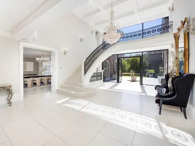 a living room with a staircase and a chandelier at The Essex Mansion - Uk48355 in Romford