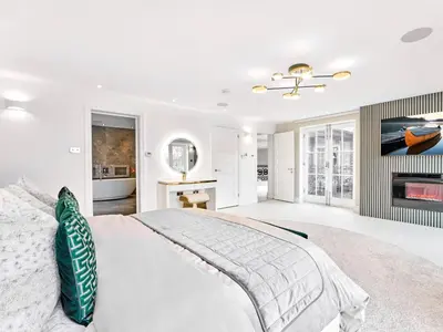 a white bedroom with a bed and a fireplace at The Essex Mansion - Uk48355 in Romford