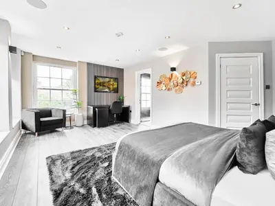 a bedroom with a large bed and a living room at The Essex Mansion - Uk48355 in Romford