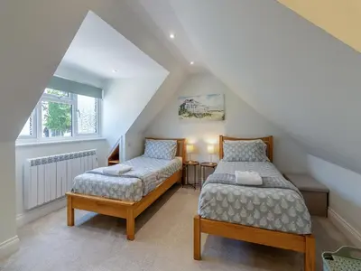 a attic bedroom with two beds and a window at Olive Breeze in Felixstowe