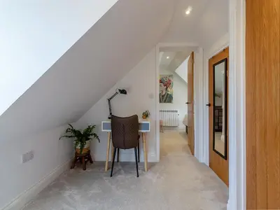 a staircase with a chair and a table in a room at Olive Breeze in Felixstowe