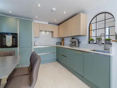 a kitchen with blue cabinets and a table and chairs at Olive Breeze in Felixstowe