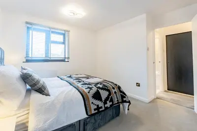 a white bedroom with a bed and a window at A lovely modern comfortable one bedroom house - Pass the Keys in Southend-on-Sea