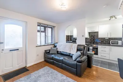 a living room with a couch and a kitchen at A lovely modern comfortable one bedroom house - Pass the Keys in Southend-on-Sea