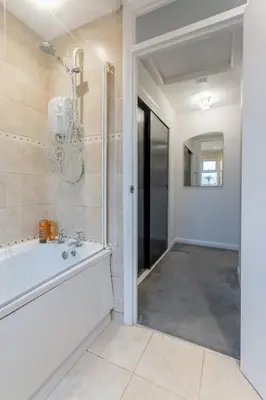 a bathroom with a bath tub and a mirror at A lovely modern comfortable one bedroom house - Pass the Keys in Southend-on-Sea