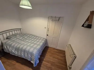 a small bedroom with a bed and a door at Stoke house in Ipswich