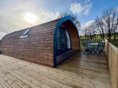 a circular building with a table on a deck at River Meadow Retreat in Hilgay
