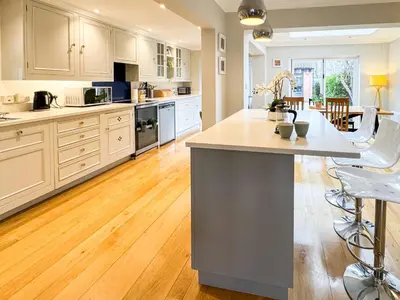 a kitchen with white cabinets and a large island at Stunning City Home with Private Heated Indoor Pool & Cinema Room in Cambridge