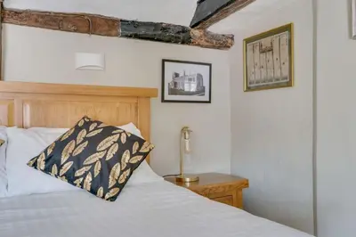a bedroom with a bed with a wooden headboard at Winter Cottage, Clare in Clare